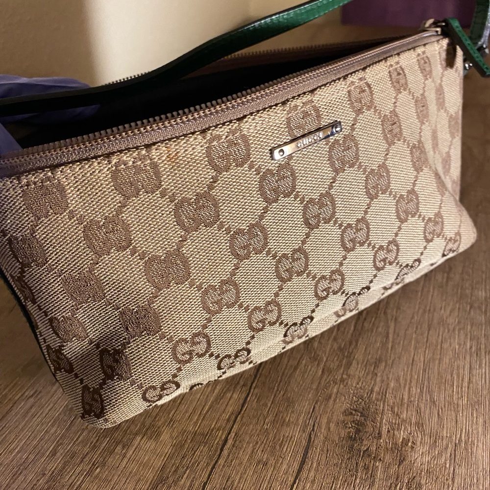 Classic Gucci design wristlet with green leather accent trim.